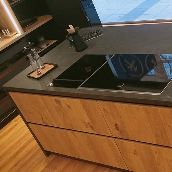 Isla de porcelánico con vitrocerámica Dekton Laos industrial
