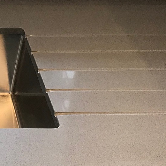 encimera de cuarzo Compac Smoke Grey con ranuras de drenaje