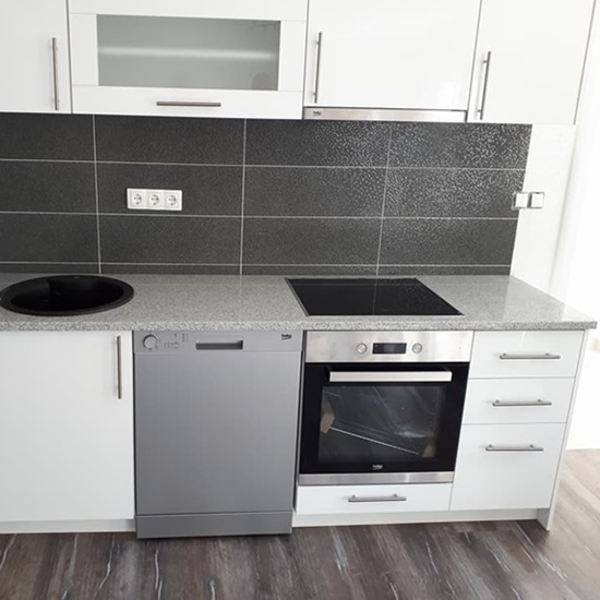 una cocina con muebles blancos y encimera deGranito Blanco Cristal