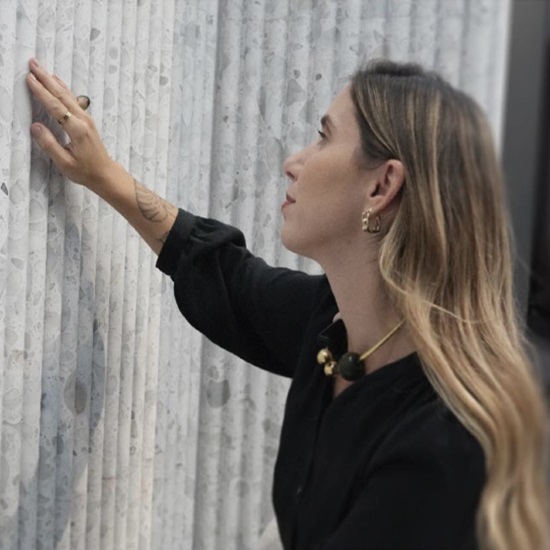 mujer tocando una pared terrazo blanco Doge