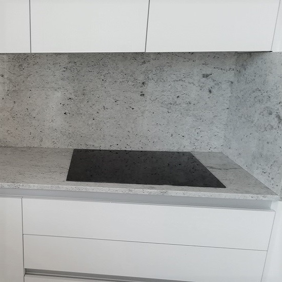 una foto de cerca de encimera y salpicadero de Granito Colonial White