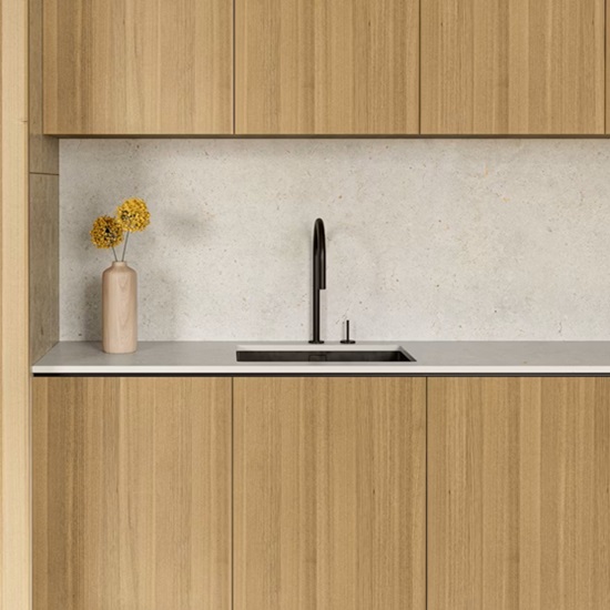 una cocina con muebles de madera y encimera y salpicadero Dekton Polar