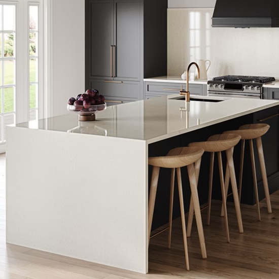 una isla en Silestone Linen Cream con cascada haciendo juego